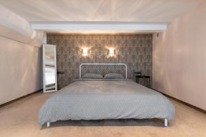 Spacious & Cozy loft Near Old Town في فيلنيوس: غرفة نوم بسرير وجدار