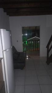 a living room with a couch and a refrigerator at Residencial Roots Rosa in Imbituba