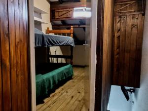 a small room with a bunk bed and a green couch at Residencial Roots Rosa in Imbituba +14 photos