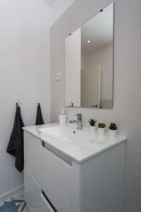 a white bathroom with a sink and a mirror at Mouraria Lisbon Soul Apartments T1 - 4 pax in Lisbon