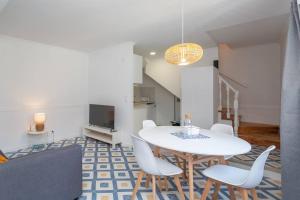 a dining room with a white table and white chairs at Mouraria Lisbon Soul Apartments T1 - 4 pax in Lisbon