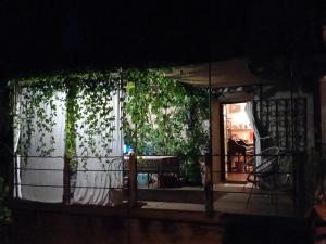 een veranda van een huis met gordijnen en een tafel bij la maison d'Anna chambres d hôtes in Ganac