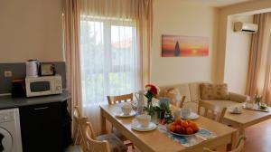 eine Küche und ein Wohnzimmer mit einem Tisch und Obst darauf in der Unterkunft Бяла Виста Бийч Апартментс B - Byala Vista Beach Apartments B in Byala
