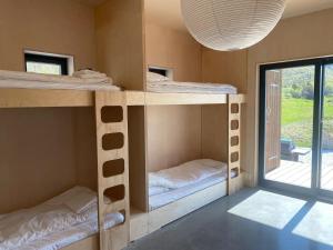 a room with four bunk beds and a large window at Exclusive Beach House Ramberg in Ramberg