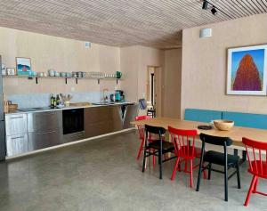 a kitchen with a wooden table and red chairs at Exclusive Beach House Ramberg - Your Private Oasis in Ramberg