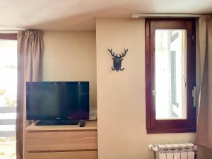 a living room with a tv and a deer head on the wall at Alpine Studio with Garage in Breuil