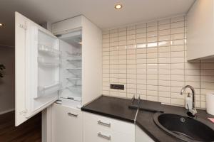 a kitchen with a sink and a refrigerator at Spacious & Cozy loft Near Old Town in Vilnius