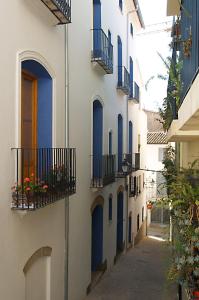 an alley with blue doors and balconies on a building at Complejo Rural La Belluga in Segorbe