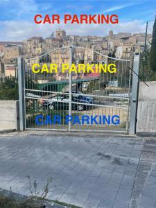a gate with the words car parking and car parking at Archetto-casa vacanze in Enna