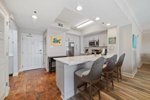 een keuken met witte kasten en een aanrecht met stoelen bij Palm Beach Resorts C55 in Gulf Shores