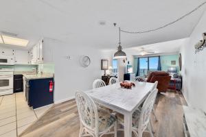 a kitchen and dining room with a white table and chairs at Phoenix 1093 in Orange Beach