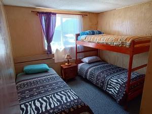 - une chambre avec 2 lits superposés et une fenêtre dans l'établissement Cabañas Hornopirén, à Hornopirén