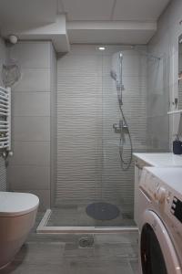 a bathroom with a shower with a toilet and a sink at GM SkyView Luxury Flatiron apartment Skopje in Skopje +13 photos