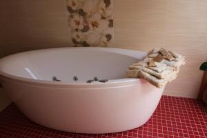 y baño con bañera blanca y toallas. en Kernavės SPA Pajauta, en Kernavė