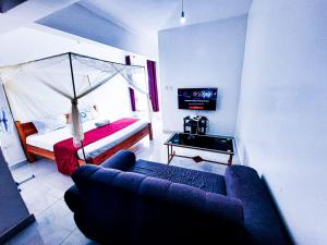 een woonkamer met een bank en een bed bij Studio at Kisimani Heights Apartment. in Mombasa