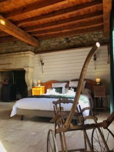 een slaapkamer met een bed en een houten plafond bij Le petit château du Villard 