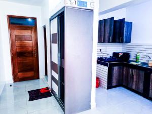 een keuken met een deur en een keuken met een aanrecht bij Studio at Kisimani Heights Apartment. in Mombasa