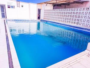 een zwembad met blauw water naast een gebouw bij Studio at Kisimani Heights Apartment. in Mombasa