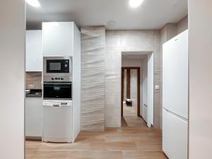 a kitchen with white appliances and a hallway at Fee4Me La Azotea de Morata in Morata de Tajuña