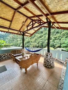a pavilion with a couch and a table on a patio at Aussie Inn Bukit Lawang in Bukit Lawang