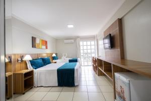 1 dormitorio con 1 cama grande con almohadas azules en DIROMA EXCLUSIVE - BVTUR, en Caldas Novas