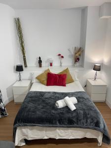 ein Schlafzimmer mit einem großen Bett mit zwei roten Kissen in der Unterkunft Resitur Luxury Suit 6 in Sevilla