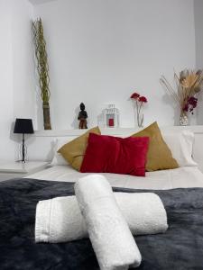 ein großes Bett mit roten und weißen Kissen darauf in der Unterkunft Resitur Luxury Suit 6 in Sevilla
