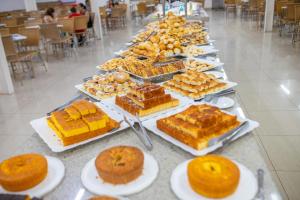 a buffet of desserts and pastries on plates on a table at DiRoma Exclusive - HUP CALDAS NOVAS in Caldas Novas