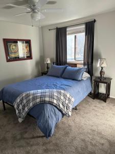 Un dormitorio con una cama azul y una ventana en Boise Bench Home-Great Location!, en Boise