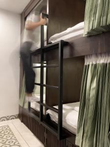 a room with a bunk bed with a person in it at Aborest Tropical Hostel in Siem Reap