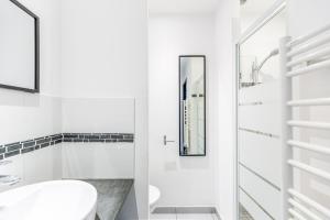W białej łazience znajduje się umywalka i lustro. w obiekcie Appartement charmant Bordeaux centre w mieście Bordeaux