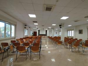 une pièce vide avec des chaises et un podium dans l'établissement Apulia Hotel Roma, à Rome