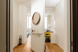 un corridoio con pareti bianche, specchio e tavolo di Open space nel pieno centro di Brescia a Brescia