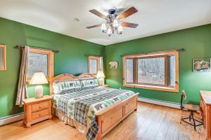 a bedroom with green walls and a bed and a ceiling fan at Secluded Adirondack Cabin about 5 Mi to Sacandaga Lake in Broadalbin