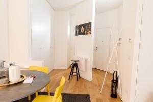 ein Esszimmer mit einem Tisch und gelben Stühlen in der Unterkunft Open space nel pieno centro di Brescia in Brescia