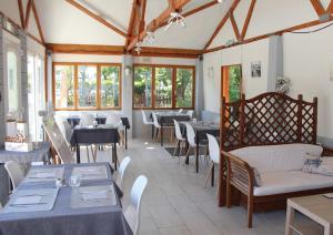 - une salle à manger avec des tables, des chaises et des fenêtres dans l'établissement Camping Le Picard, à Tournières