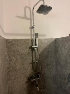 una ducha en la pared con cabezal de ducha en Malcom Residence en Pongwe