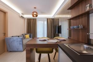 a kitchen and living room with a table and a couch at GM SkyView Luxury Flatiron apartment Skopje in Skopje