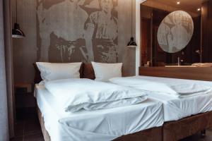 two beds with white sheets in a room at Encanto Hotel Restaurant in Balingen