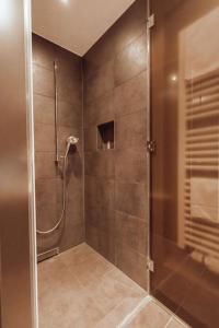 um chuveiro com uma porta de vidro na casa de banho em Encanto Hotel Restaurant em Balingen