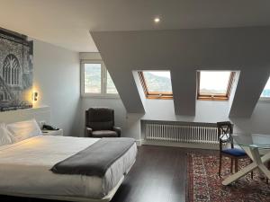 a bedroom with a bed and a chair and a glass table at Hotel Gran Regente in Oviedo