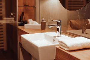 La salle de bains est pourvue d'un lavabo blanc et d'un miroir. dans l'établissement Encanto Hotel Restaurant, à Balingen