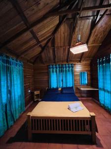 a bedroom with a large bed with blue curtains at Royal Wooden villa in Mananthavady