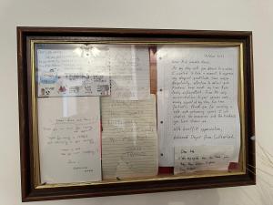 ein gerahmtes Dokument mit Schreiben an einer Wand in der Unterkunft Ashcroft Quiet Garden House-London Luton Airport in Luton