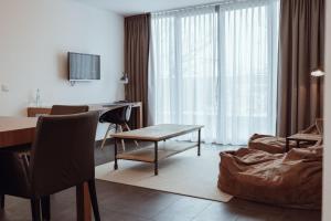 a living room with a table and a couch at Encanto Hotel Restaurant in Balingen