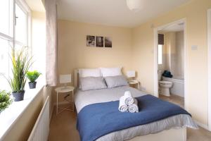 ein Schlafzimmer mit einem Bett mit zwei Handtüchern darauf in der Unterkunft Guildford Townhouse with Parking in Guildford + 17 Fotos