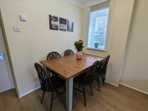 a dining room with a wooden table and chairs at Guildford Townhouse with Parking in Guildford