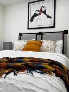 Una cama con una pila de mantas de colores. en Bambury's Hillside Chalets, en Rocky Harbour