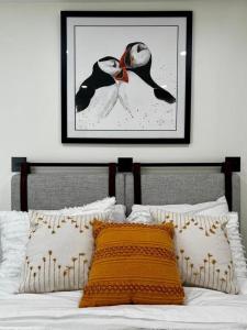 ein Schlafzimmer mit einem Bett mit einem Bild an der Wand in der Unterkunft Bambury's Hillside Chalets in Rocky Harbour