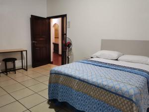 a bedroom with a bed and a table and a door at Hotel Ghiza in Tegucigalpa